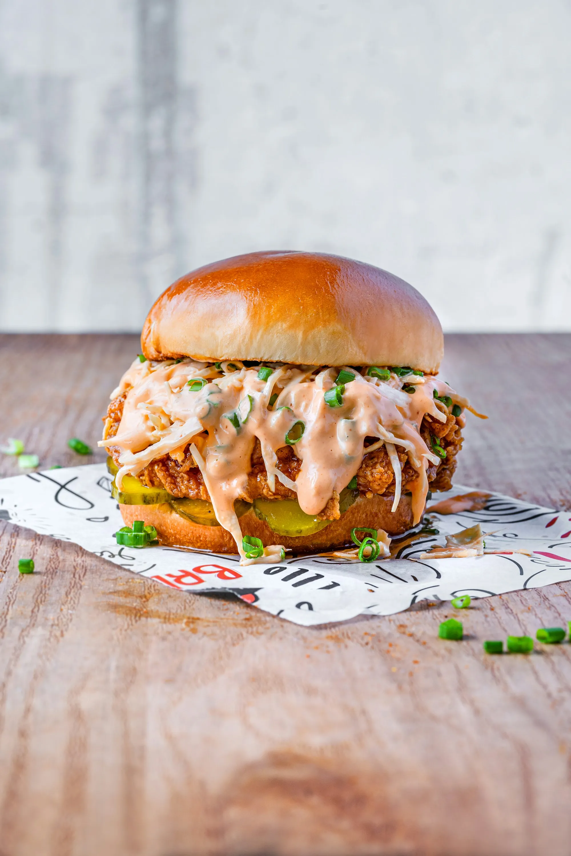 Crispy fried chicken sandwich stacked with slaw, pickles, and comeback sauce on a brioche bun